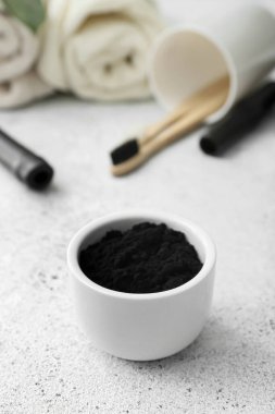 Açık arkaplanda aktif kömür diş pudrası olan kase