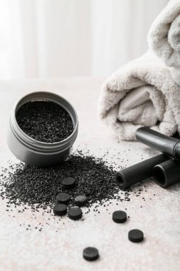 Kavanoz aktif kömür diş tozu ve masada haplar.