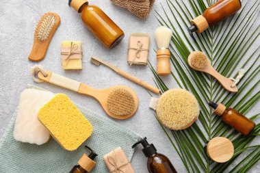 Süngerli banyo malzemeleri ve arka planda palmiye yaprağı.