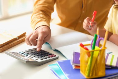 Küçük kızına evde ders vermesi için yardım eden bir adam.