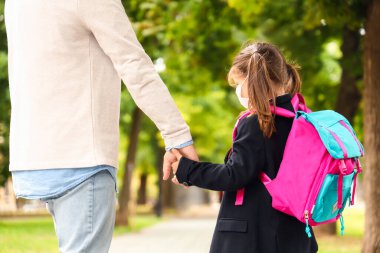 Küçük kızını okula götüren adam.