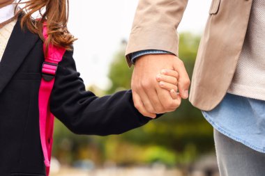 Küçük kızını okula götüren adam, yakın çekim.