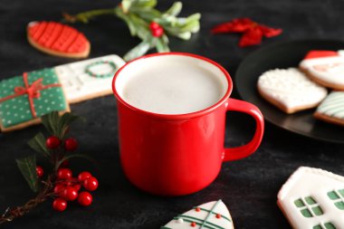 Lezzetli kakaolu fincan ve koyu arkaplanda güzel Noel kurabiyeleri.