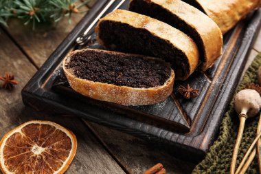 Ahşap arka planda lezzetli haşhaşlı çörekler, yakın plan.