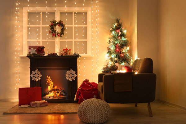 Interior of living room with fireplace, Christmas tree and glowing lights