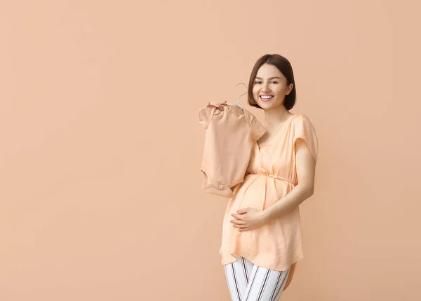 Ung Gravid Kvinna Med Baby Bodysuit Beige Bakgrund — Stockfoto