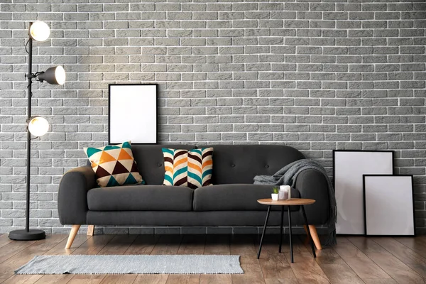 Stylisches Dunkles Sofa Mit Leeren Postern Der Nähe Der Ziegelwand — Stockfoto