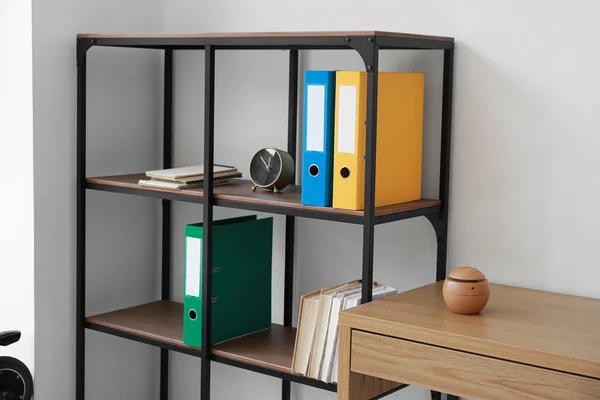 Shelving Unit Folders Books Alarm Clock Light Wall — Stock Photo, Image