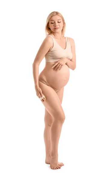白い背景にマッサージブラシと美しい妊娠中の女性 — ストック写真