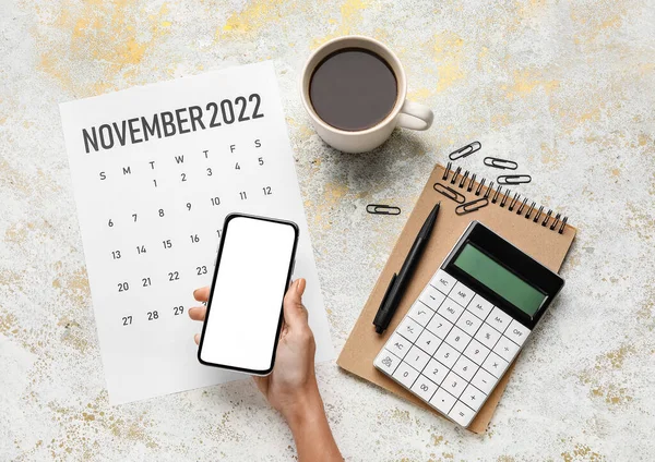Weibliche Hand Mit Handy Papierkalender Für November 2022 Tasse Kaffee — Stockfoto