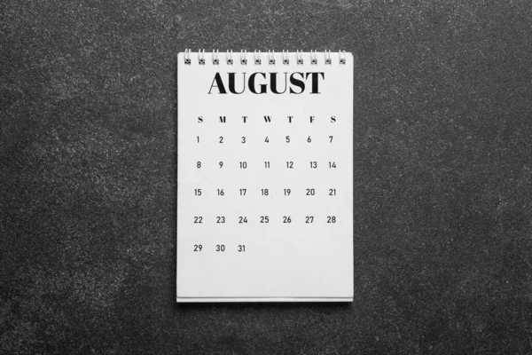 Flip paper calendar for August 2022 on dark background