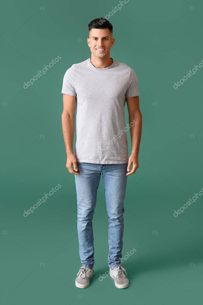 Handsome young man in stylish t-shirt on color background