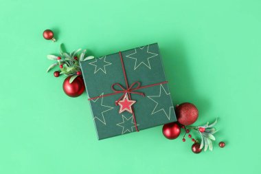 Noel hediyesi kutusu ve yeşil arka planda toplar
