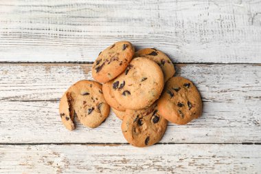 Hafif ahşap arka planda çikolata parçalı lezzetli ev yapımı kurabiyeler.