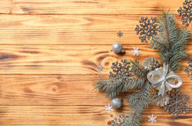 Güzel kar taneleri, Noel süsleri ve ahşap arka planda köknar dalları.