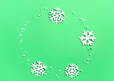 Yeşil zemin üzerinde güzel kar tanelerinden yapılmış çerçeve