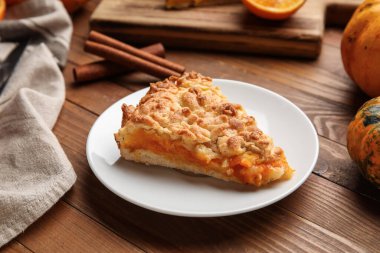 Ahşap zemin üzerinde taze balkabağı turtası olan bir tabak.