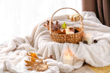 Tutucularda mum yakmak ve odada yumuşak ekose üzerinde sonbahar dekoru.