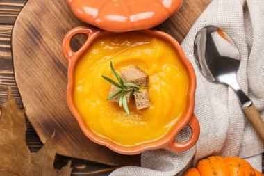 Ahşap zemin üzerinde lezzetli balkabağı kremalı çorba.