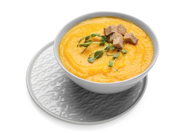 Beyaz arka planda bir kase lezzetli balkabağı kremalı çorba.