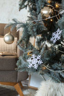 Topları, kar taneleri ve parıldayan ışıkları olan Noel ağacı, yakın plan.