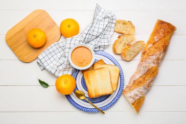 Lezzetli bir kase mandalina reçeli ve hafif ahşap arka planda ekmekli kompozisyon