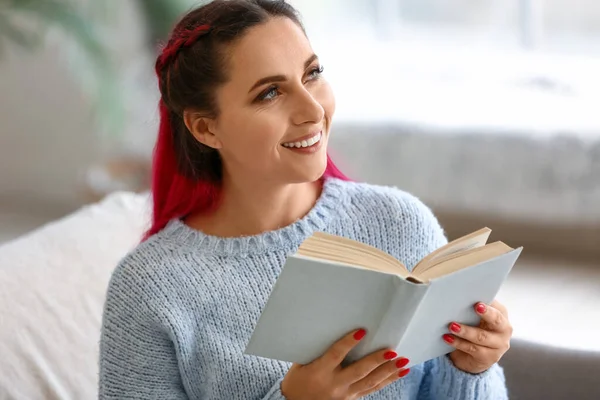 Mavi Kazaklı Güzel Bir Kadın Evdeki Kanepede Kitap Okuyor — Stok fotoğraf