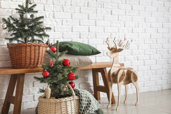 白いレンガの壁の近くに美しい装飾クリスマスツリーとトナカイ — ストック写真