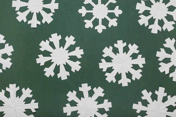 緑の背景に美しい紙の雪片 — ストック写真