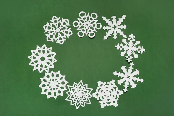 緑の背景に美しい紙の雪片で作られたフレーム — ストック写真