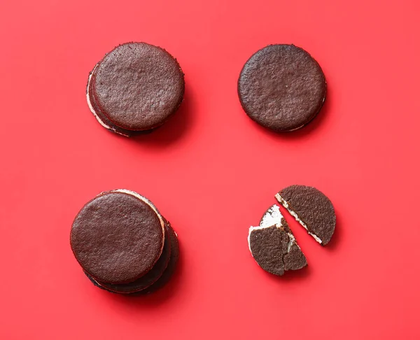 Tasty chocolate cookies with cream on red background