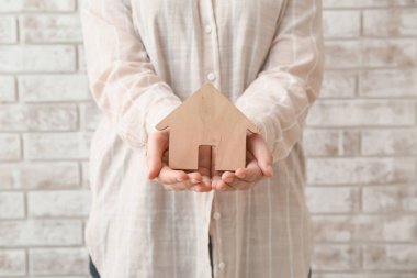 Tuğla kaplı ahşap evi olan bir emlakçı.