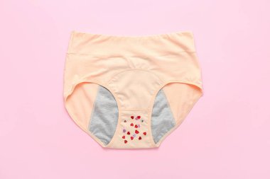 Pembe arka planda adet külotu ve pulları