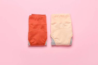 Pembe arka planda katlanmış adet külotu