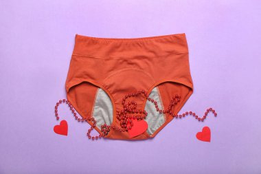 Dönem külotlu, boncuklu ve renkli arka planda kağıt kesikli kalpleri olan kompozisyon