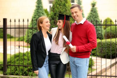 Mezuniyet gününde ailesiyle mutlu genç kadın