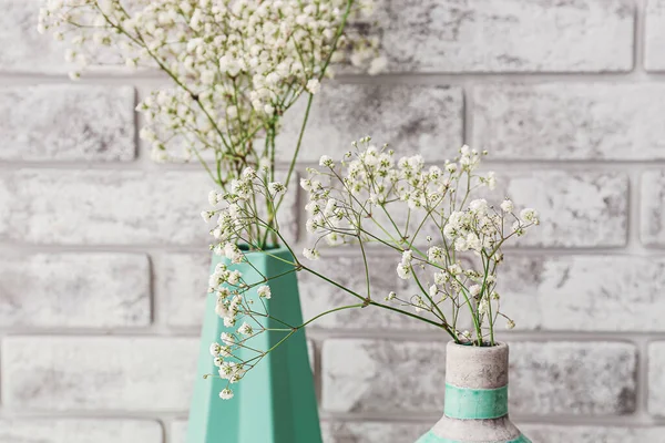 Tuğla arka planda güzel çingene çiçekleri olan vazolar, yakın plan.