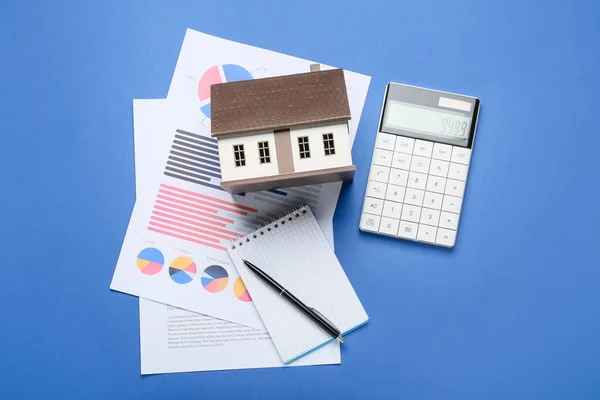 Modelo Casa Con Diagramas Cuaderno Calculadora Sobre Fondo Azul — Foto de Stock