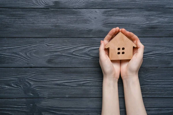 Manos Femeninas Casa Madera Sobre Fondo Madera Oscura Concepto Inmobiliario — Foto de Stock