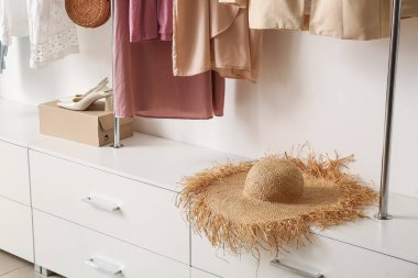 Gardıroptaki rafta duran zarif hasır şapka