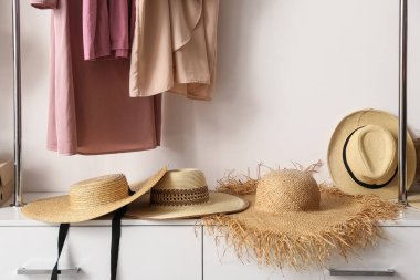 Gardıroptaki raflarda modaya uygun hasır şapkalar