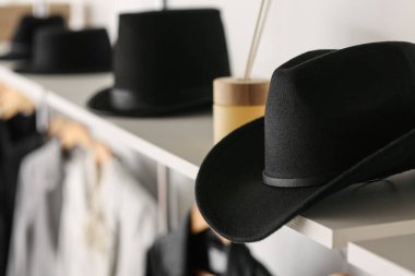 Şık keçeli şapka gardıropta rafta, yakın plan