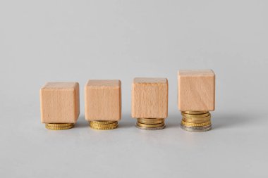 Gri arkaplanda tahta küpler ve madeni paralar