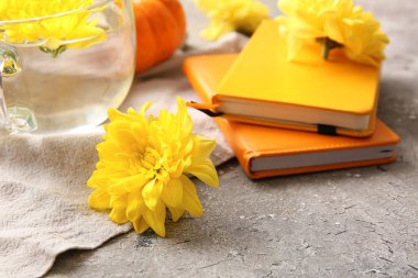 Not defterleri ve gri arka planda sarı kasımpatı çiçekleri