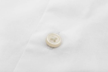 Açık renk gömlekli düğme, yakın plan.