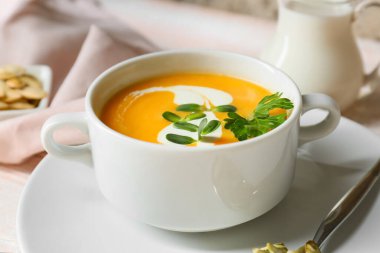 Lezzetli kabak kremalı tencere ve tohumlar masada, yakın plan.