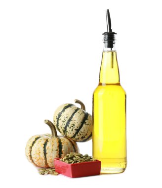 Beyaz arka planda bir şişe balkabağı tohumu yağı