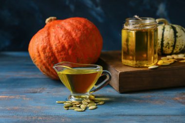 Tahta masada bir sürahi kabak tohumu yağı.