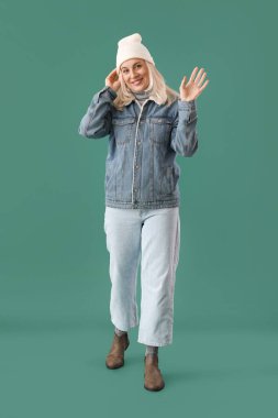 Renkli arka planda kalın giysiler içinde güzel olgun bir kadın.