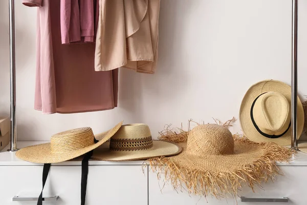 Gardıroptaki raflarda modaya uygun hasır şapkalar